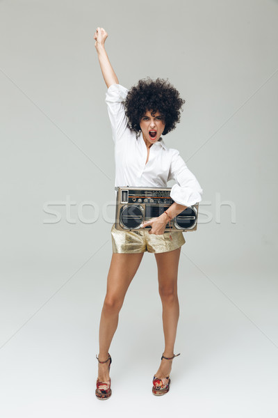 Emotional retro woman dressed in shirt holding boombox. Stock photo © deandrobot