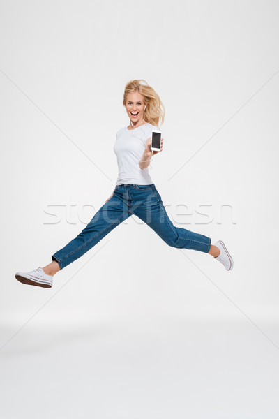 Stock photo: Full length portrait of a happy excited casual blonde woman