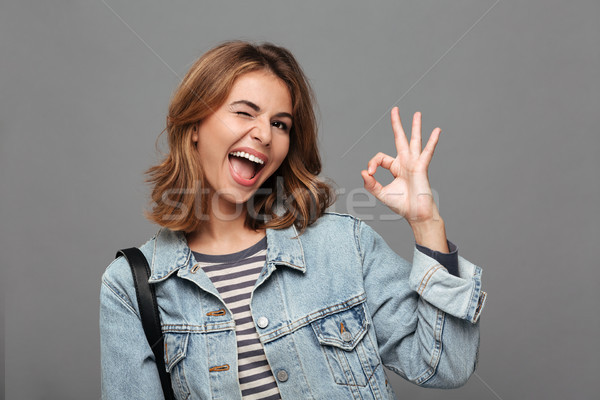 Portrait of a cheery teenage girl dressed in denim jacket Stock photo © deandrobot
