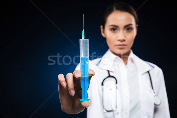 Close up of young doctor holding syringe isolated Stock photo © deandrobot