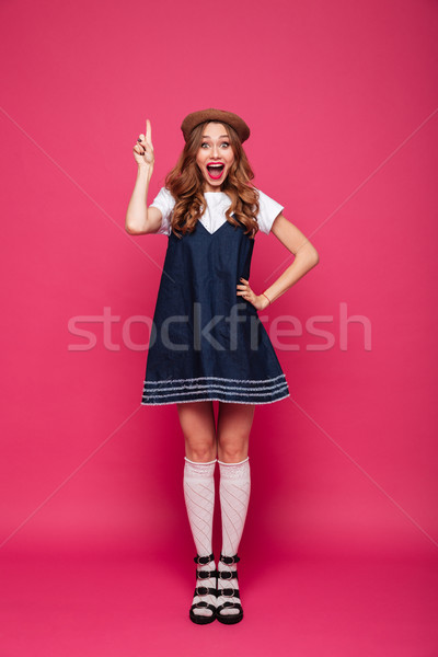 Beautiful happy woman holding finger up while have an idea isolated Stock photo © deandrobot