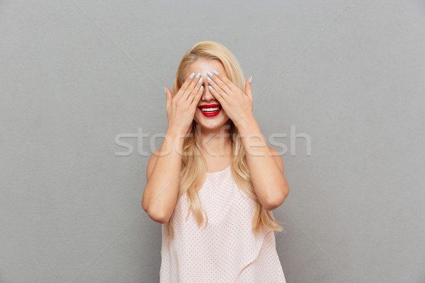 Portrait of a happy woman covering eyes with hands Stock photo © deandrobot