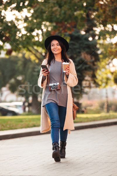 Full lenth photo of pretty modern asian girl holding smartphone  Stock photo © deandrobot