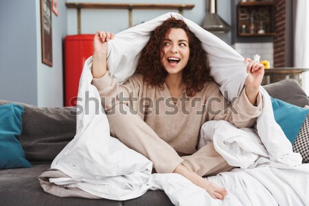 Excited young woman trying on new shoes Stock photo © deandrobot