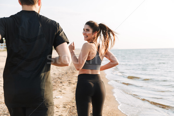 Back view of a happy young couple jogging together Stock photo © deandrobot