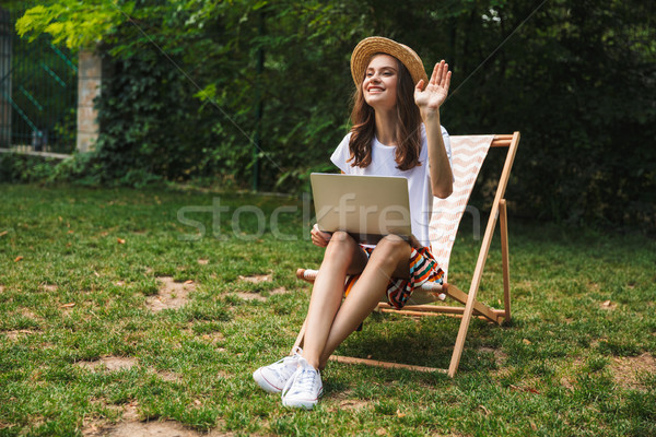 Gülen genç kız oturma dizüstü bilgisayar park açık havada Stok fotoğraf © deandrobot