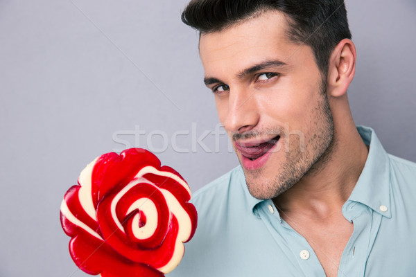 Portrait of a young man holding lollipop Stock photo © deandrobot