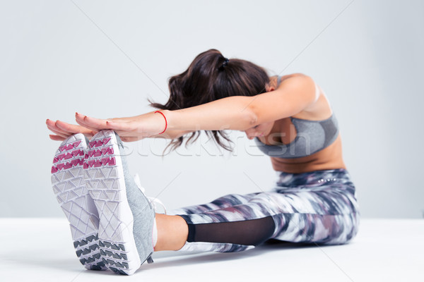 Portrait of a woman stretching on the floor Stock photo © deandrobot