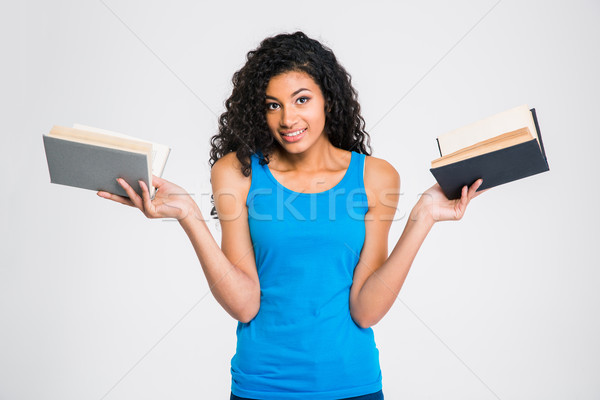 Smiling afro american woman holding two books Stock photo © deandrobot