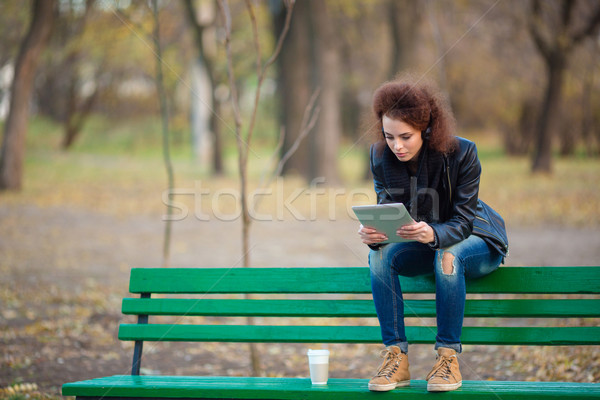 Woman sitting on the bench and using tablet computer Stock photo © deandrobot