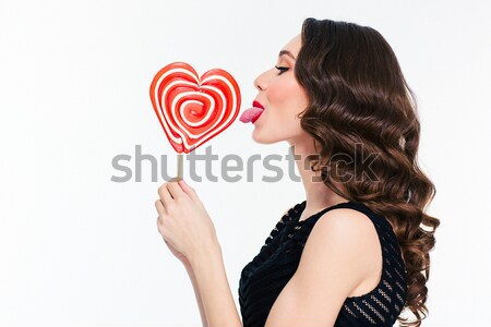 Attractive young woman holding  heart shaped lollipop  Stock photo © deandrobot