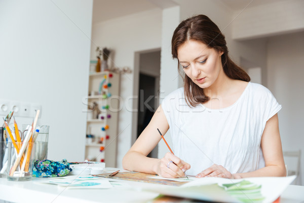 Beautiful inspired woman painter painting in art studio Stock photo © deandrobot