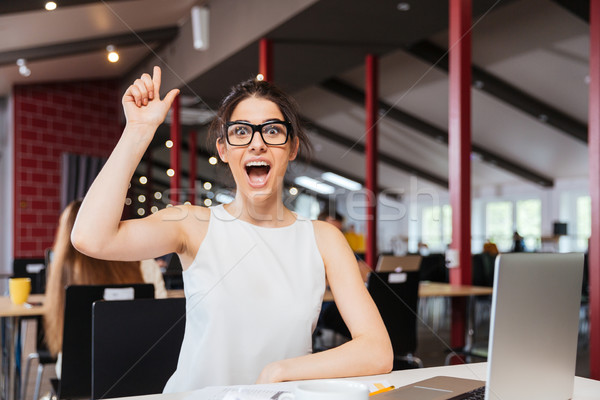 Cheerful excited businesswoman having an idea working in office Stock photo © deandrobot