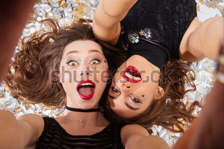 Two sexy young women with gothic halloween makeup lying Stock photo © deandrobot