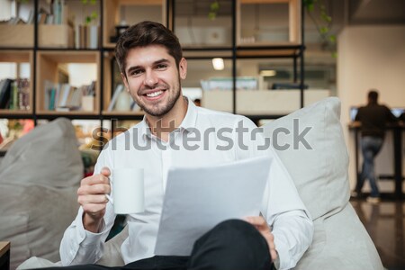 Smiling young businessman using cell phone outdoors Stock photo © deandrobot