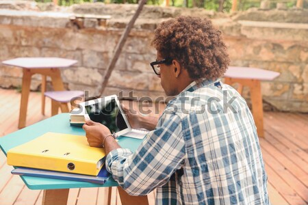 Vista posterior África hombre sesión tableta joven Foto stock © deandrobot