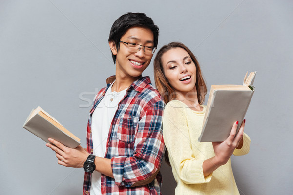 Tineri multicultural cuplu lectură cărţi împreună Imagine de stoc © deandrobot
