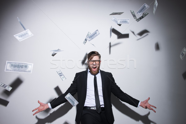 Young Business man with falling money Stock photo © deandrobot