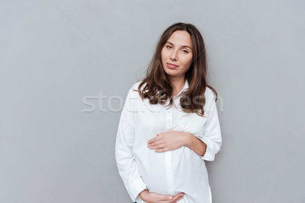 [[stock_photo]]: Cute · femme · enceinte · studio · regarder · caméra · isolé