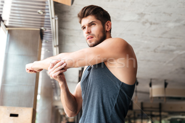 Fitness man warming up in gym Stock photo © deandrobot