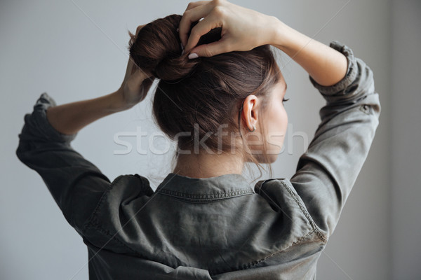 Widok z tyłu młoda kobieta shirt odizolowany szary twarz Zdjęcia stock © deandrobot