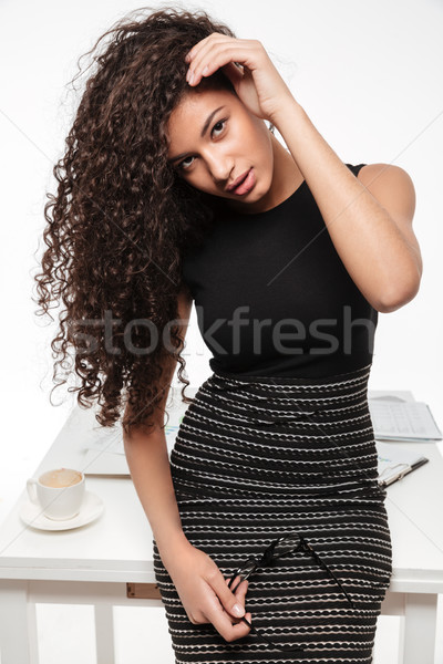 Attractive young curly african lady posing over white background. Stock photo © deandrobot