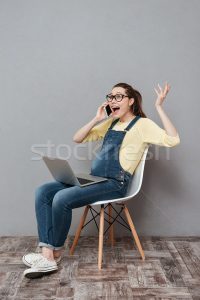 Gravidă fericit doamnă folosind laptop calculator vorbesc Imagine de stoc © deandrobot