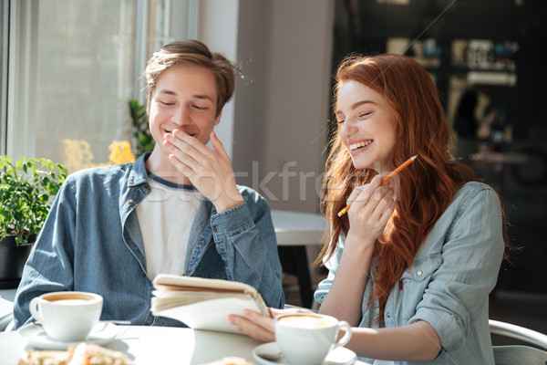 Students boy and girl laughing in cafe Stock photo © deandrobot