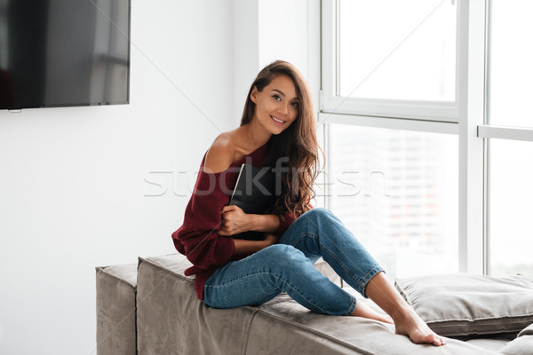 Smiling pretty woman in sweater holding tablet computer Stock photo © deandrobot