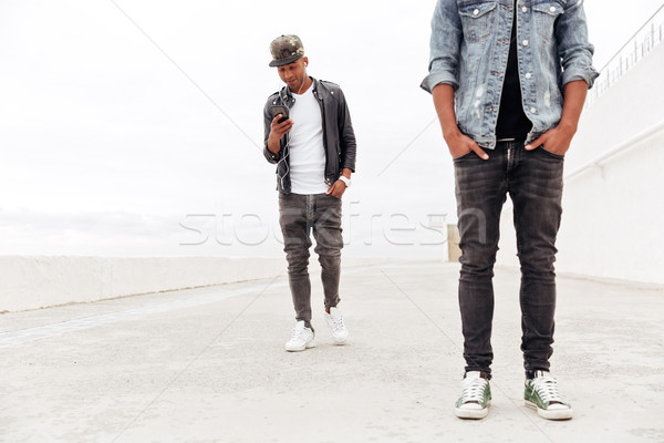 Man looking aside using phone and listening music. Stock photo © deandrobot