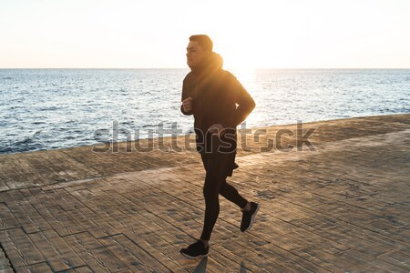 Slim fitness woman in sport wear running at the seaside Stock photo © deandrobot