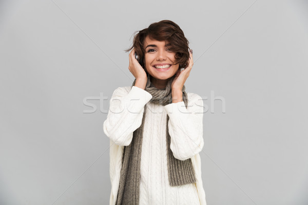 Happy young pretty woman wearing scarf standing isolated Stock photo © deandrobot