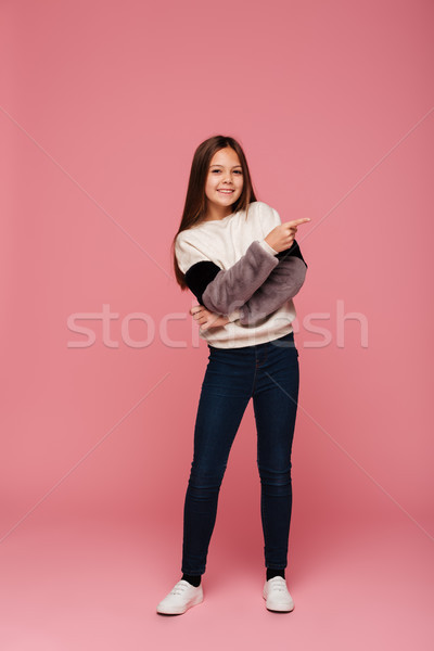 Fotografia happy girl wskazując kopia przestrzeń odizolowany szczęśliwy Zdjęcia stock © deandrobot