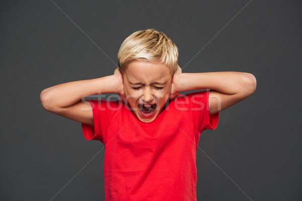 Screaming little boy child covering ears with hands. Stock photo © deandrobot