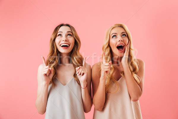 Twee gelukkig mooie vrouwen pyjama wijzend Stockfoto © deandrobot