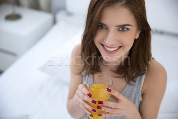 Felice donna bere succo d'arancia letto ragazza Foto d'archivio © deandrobot