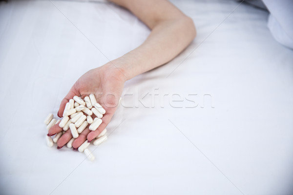 Closeup image of a female hand holding pills Stock photo © deandrobot