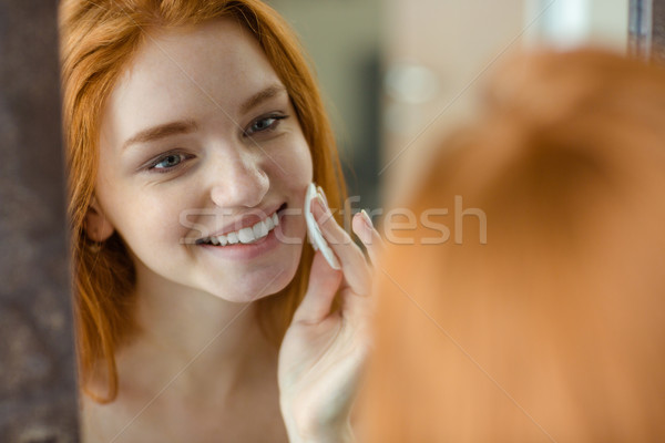 Woman with wadding looking at her reflection in mirror Stock photo © deandrobot