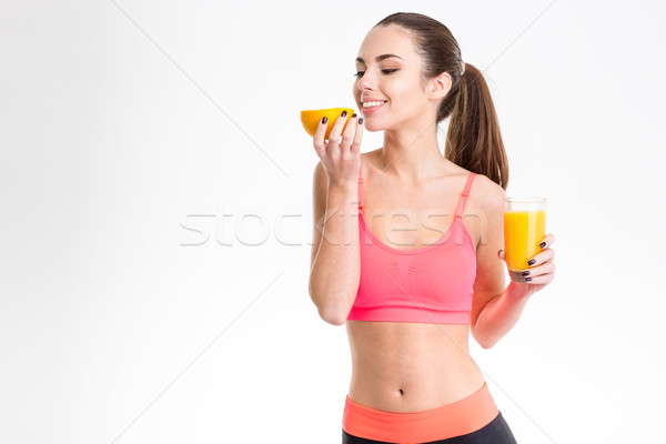 Gyönyörű sportoló narancs tart üveg dzsúz Stock fotó © deandrobot