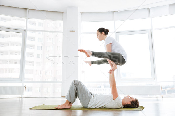 Man and woman doing acro yoga in pair Stock photo © deandrobot