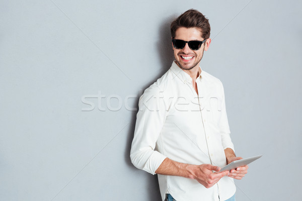 Portrait of a young happy man holding tablet computer Stock photo © deandrobot