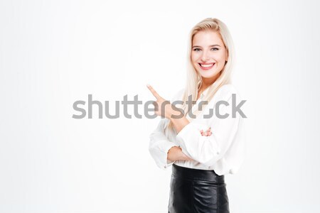 Cheerful attractive young businesswoman standing and pointing away Stock photo © deandrobot