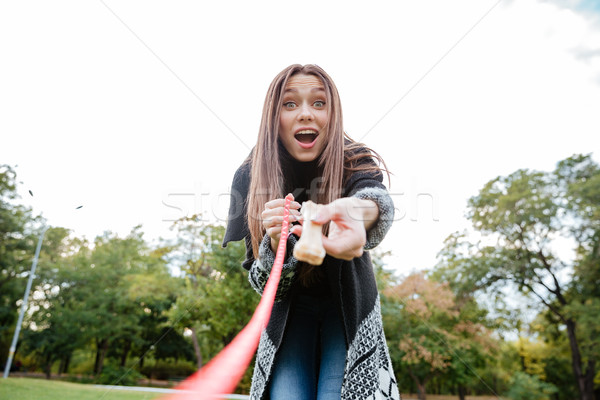 Smiling amazed young woman showing bone to her dog Stock photo © deandrobot