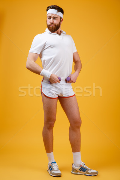 Vertical image of serious sportsman posing in studio Stock photo © deandrobot