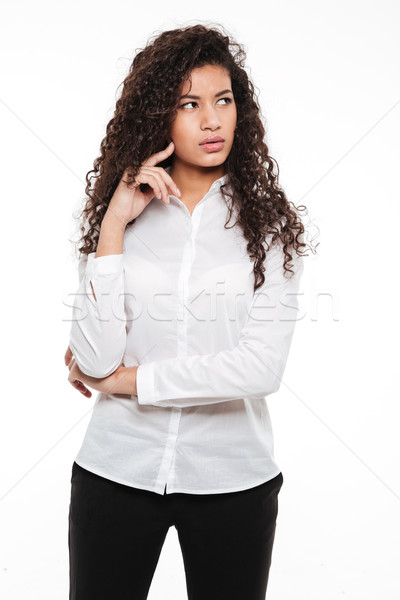 Confused young curly african lady posing over white background. Stock photo © deandrobot