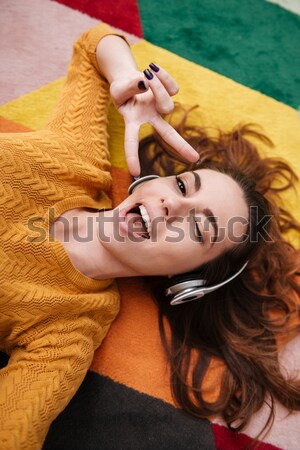 Portrait of a young smiling girl in headphones enjoying music Stock photo © deandrobot