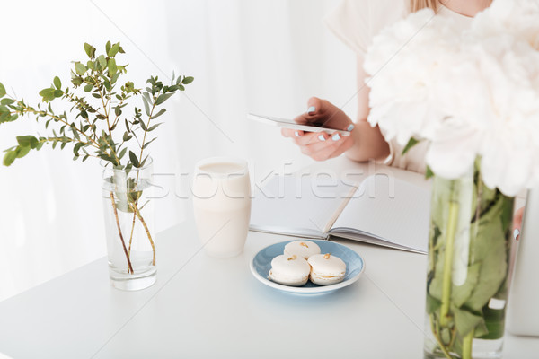 Cropped image of young woman sitting indoors make photo Stock photo © deandrobot