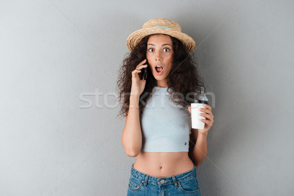 Megrémült fürtös nő kalap beszél okostelefon Stock fotó © deandrobot