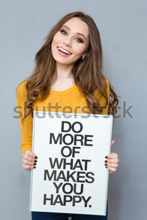 Attractive young caucasian lady holding blank with text about feminism. Stock photo © deandrobot
