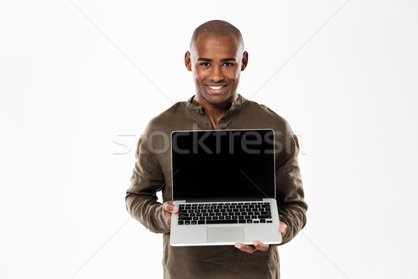 Happy african man showing blank laptop computer screen Stock photo © deandrobot